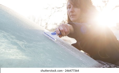 Woman Scraping Ice From Car Windshield