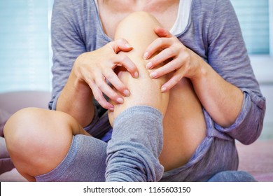 Woman Scratching Her Leg On Couch
