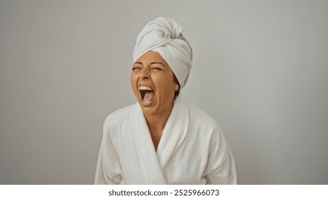 Woman screaming with mouth open, middle-aged, brunette, hispanic, isolated on white background, wearing bathrobe and towel turban - Powered by Shutterstock