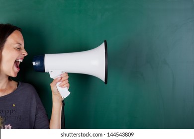 Woman screams into megaphone in front of a blackboard - Shutterstock ID 144543809