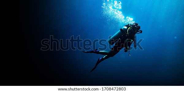 Woman scuba diving in deep blue sea banner on\
black background