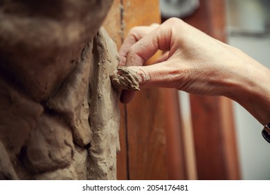 Woman sculptor at work. Sculptor's hand close up.