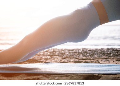 Woman sea pilates. Sporty happy middle aged woman practicing fitness on beach near sea, smiling active female training on yoga mat outside, enjoying healthy lifestyle, harmony and meditation. - Powered by Shutterstock