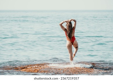 Woman sea yoga. Back view of free calm happy satisfied woman with long hair standing on top rock with yoga position against of sky by the sea. Healthy lifestyle outdoors in nature, fitness concept - Shutterstock ID 2367219357