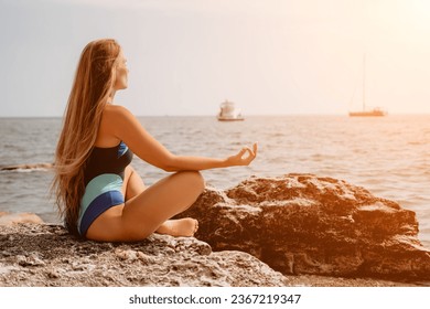 Woman sea yoga. Happy woman meditating in yoga pose on the beach, ocean and rock mountains. Motivation and inspirational fit and exercising. Healthy lifestyle outdoors in nature, fitness concept. - Shutterstock ID 2367219347