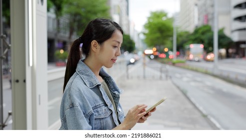 Woman Search The Bus Time Table On Cellphone In The Bus Stop In Taipei City