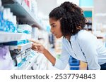 Woman, search and reading with medicine at pharmacy for OTC pills, label and decision by shelf. Healthcare, drugstore and female customer with info on box for medical product, choice and supplements