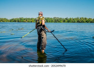  A Woman Searches For Precious Metals In The River With A Metal Detector.