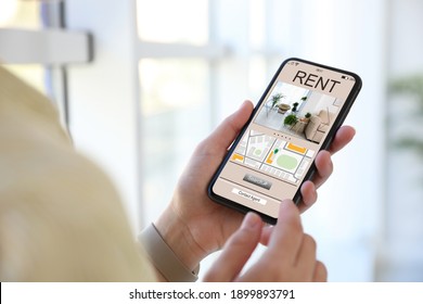 Woman Searching For Apartment On Rental Property Website Via Smartphone, Closeup