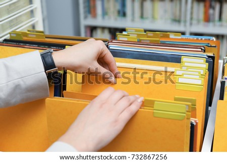 Woman searching for documents in archive