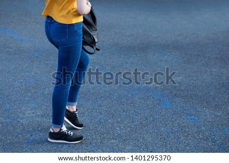 Woman searching things in her bag, blue jeans yellow shirt