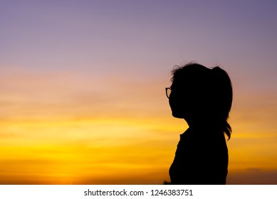Woman seated with a life time of stress in the sunset.