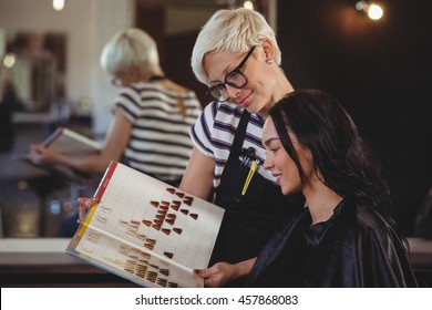 Woman selecting a hair color with stylist at the hair salon - Powered by Shutterstock