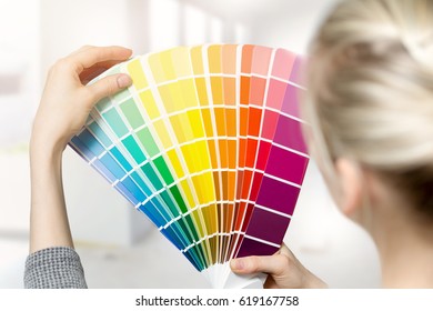 Woman Selecting Home Interior Paint Color From Swatch Catalog