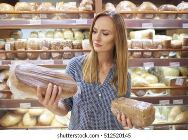 Woman Selecting Loaf Of Bread At Supermarket 