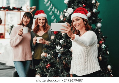 Woman, selfie and Christmas in living room with friends for holiday, celebration and together with coffee. Technology, social media and group in apartment for relax, vacation and hot drink in lounge - Powered by Shutterstock