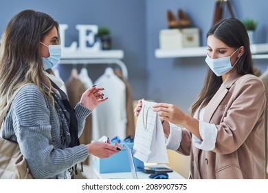 Woman Seller And Buyer In Clothes Store Wearing Mask