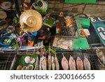 Woman selling fresh food at floating food market near Hua Hin, Thailand. South East Asia travel.