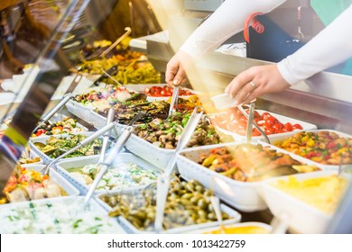Woman selling Meze appetizers in delicatessen store - Shutterstock ID 1013422759