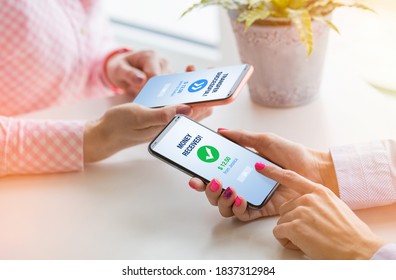 Woman sending money to her friend using mobile phone - Shutterstock ID 1837312984