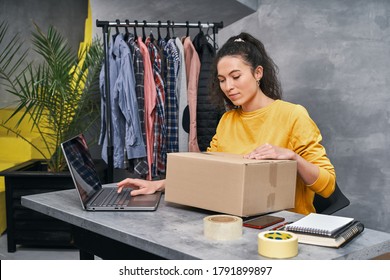 Woman Sending Parcel Using Her Laptop. Working From Home