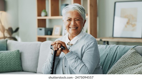 Woman, senior and portrait with cane on sofa, walking support and assistance stick in retirement home on weekend break. Smile, happiness and elderly female person with a disability, wellness and help - Powered by Shutterstock