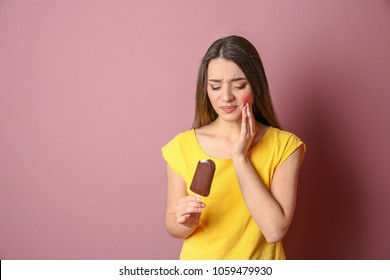 Woman With Sensitive Teeth Holding Ice Cream On Color Background