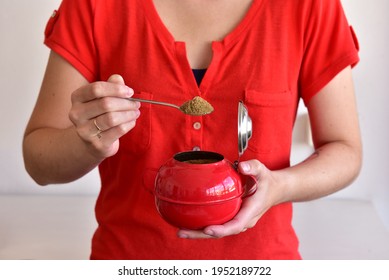 Woman Serving Brown Sugar From Red Sugar Bowl.