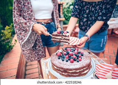 Woman Serving Chocolate Cake In A Summer Party 