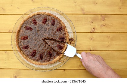 Woman serving a slice of freshly-baked pecan pie