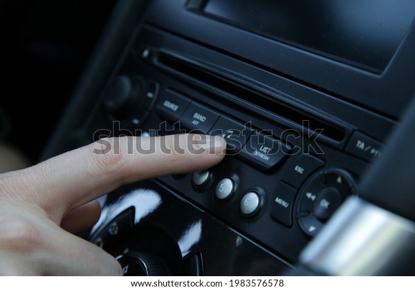 Woman set up\
music in car. Car dashboard close\
up