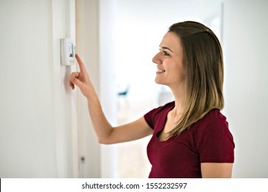 A Woman Set The Thermostat At House.