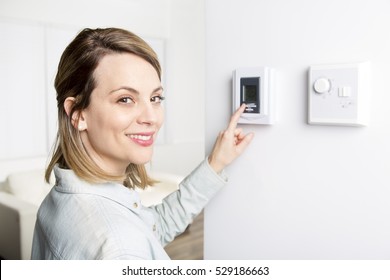 A Woman Set The Thermostat At House.