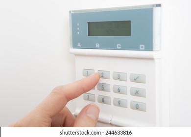 Woman Setting Control Panel On Home Security System