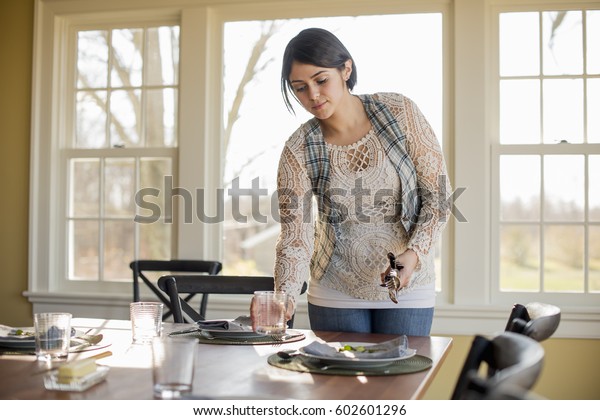 A woman setting the\
table for a meal
