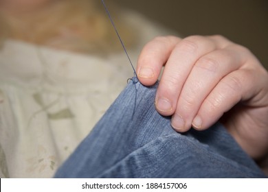 Woman Sewing Denim Blue Jeans With Blue Thread