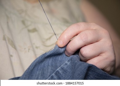 Woman Sewing Denim Blue Jeans With Blue Thread