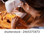 Woman, sewing machine and textile production in studio or manufacturing clothes, small business or fabric. Female person, tailor and creative entrepreneur in workshop for fashion, pattern or handmade