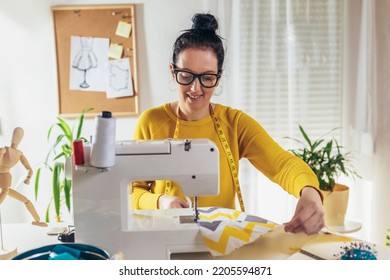 Mujer cosiendo en una máquina de coser en su casa. Las costureras trabajan en la costurera