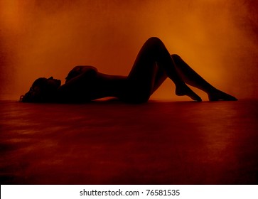 Woman sexy silhouette lying at red orange background