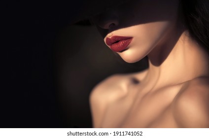 Woman in shadows. Elegant woman with red lips. elegant woman with naked shoulders on black background, copy space