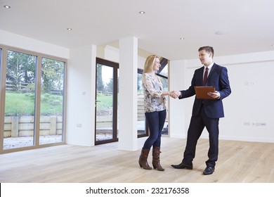 Woman Shaking Hands With Estate Agent In New Home - Shutterstock ID 232176358