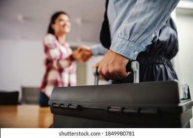 Woman shaking hands with a repairman while standing at home. - Shutterstock ID 1849980781