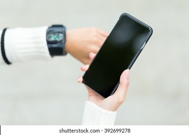 Woman share data between smart watch and cellphone