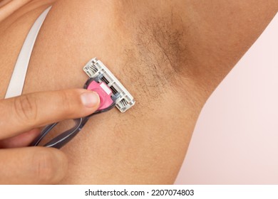Woman shave underarm hair on dry skin closeup, free copy space. Removing body hair with razor. Female beauty routine, skin care, overgrown armpits, body positive. Hygiene and smooth skin concept. - Shutterstock ID 2207074803