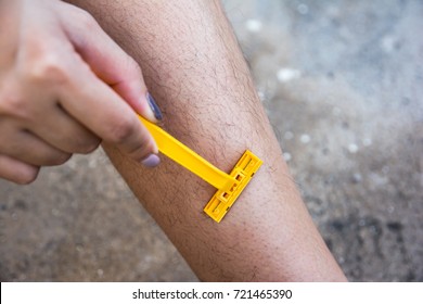 Woman Shaving Hairy Legs With Plastic Razor