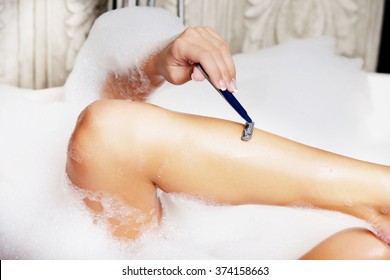 Woman shaving her leg. - Powered by Shutterstock