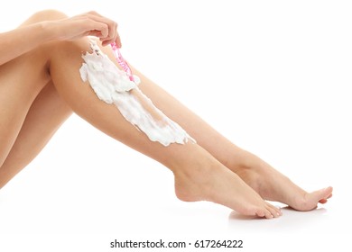Woman shaving her legs isolated on white