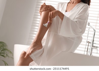 Woman shaving leg on bathtub in bathroom, closeup - Powered by Shutterstock