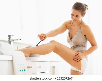Woman Shaving Legs In Bathroom